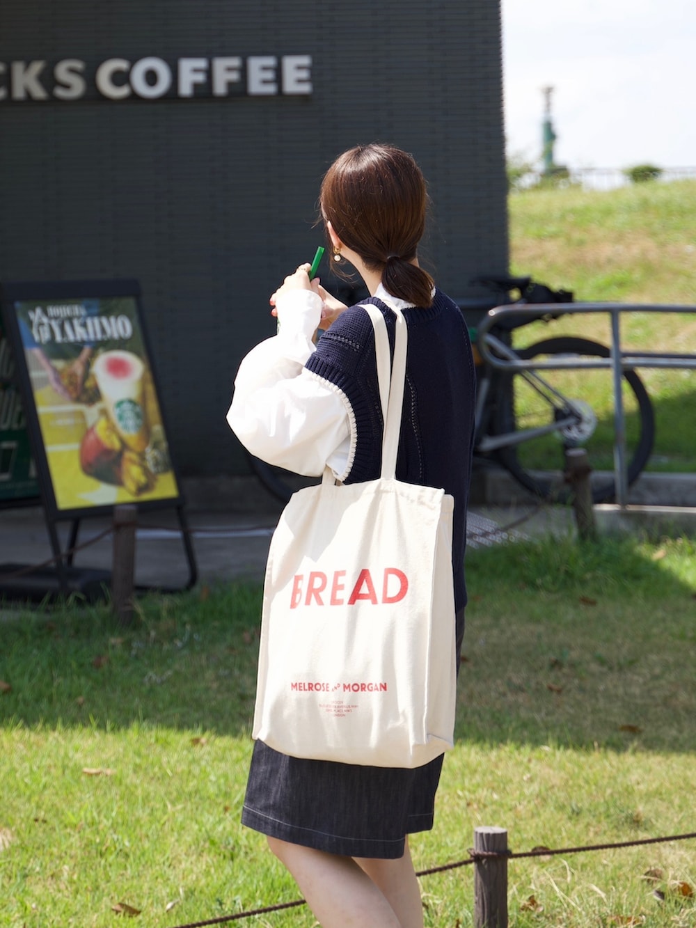 ブルー系のニット/セーター、ホワイト系のシャツ/ブラウス、ブラック系のローファーを着用したレディースの秋コーディネートの2枚目の写真