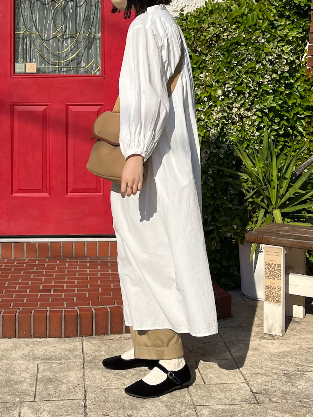 ベージュ系のショルダーバッグ、ホワイト系のワンピース、ブラック系のバレエシューズを着用したレディースの春コーディネートの3枚目の写真