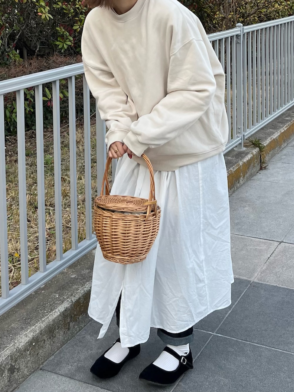 ホワイト系のスウェット、ホワイト系のシャツワンピース、ベージュ系のかごバッグを着用したレディースの春コーディネートの3枚目の写真