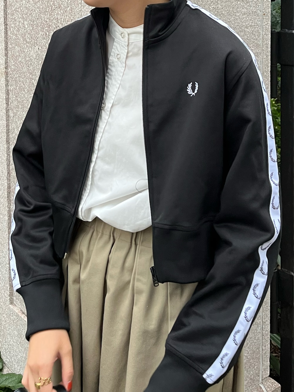 ブラック系のブルゾン、ブラック系のショルダーバッグ、ベージュ系のスカートを着用したレディースの秋コーディネートの2枚目の写真