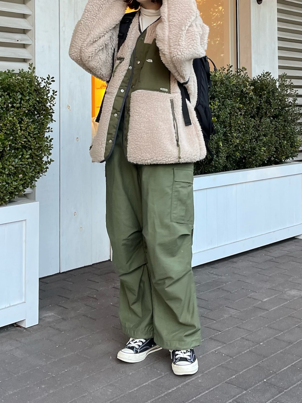 ブラック系のスニーカー、ベージュ系のブルゾン、ベージュ系のキャップを着用したレディースの冬コーディネートの2枚目の写真