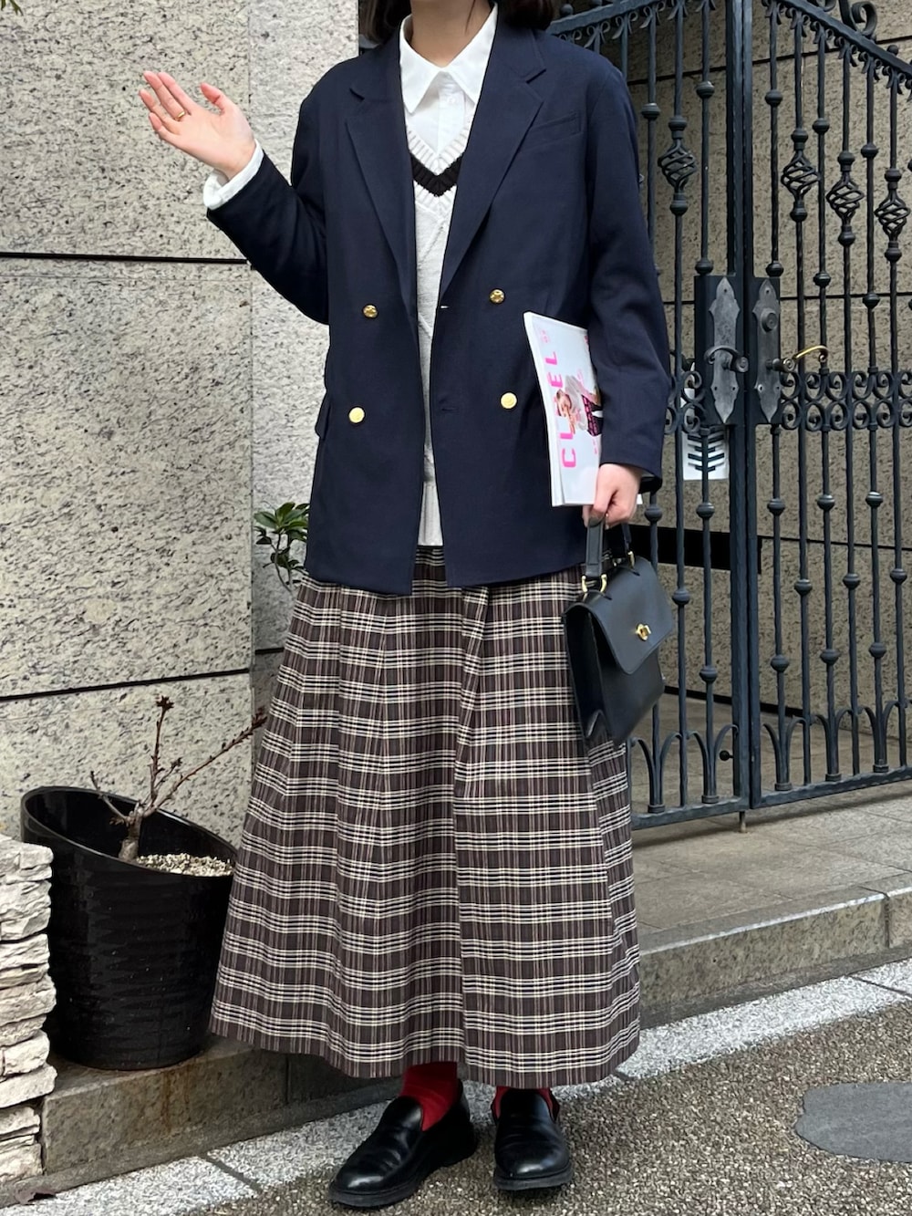 ブルー系のテーラードジャケット、ブラック系のショルダーバッグ、ブラウン系のスカートを着用したレディースの春コーディネートの2枚目の写真