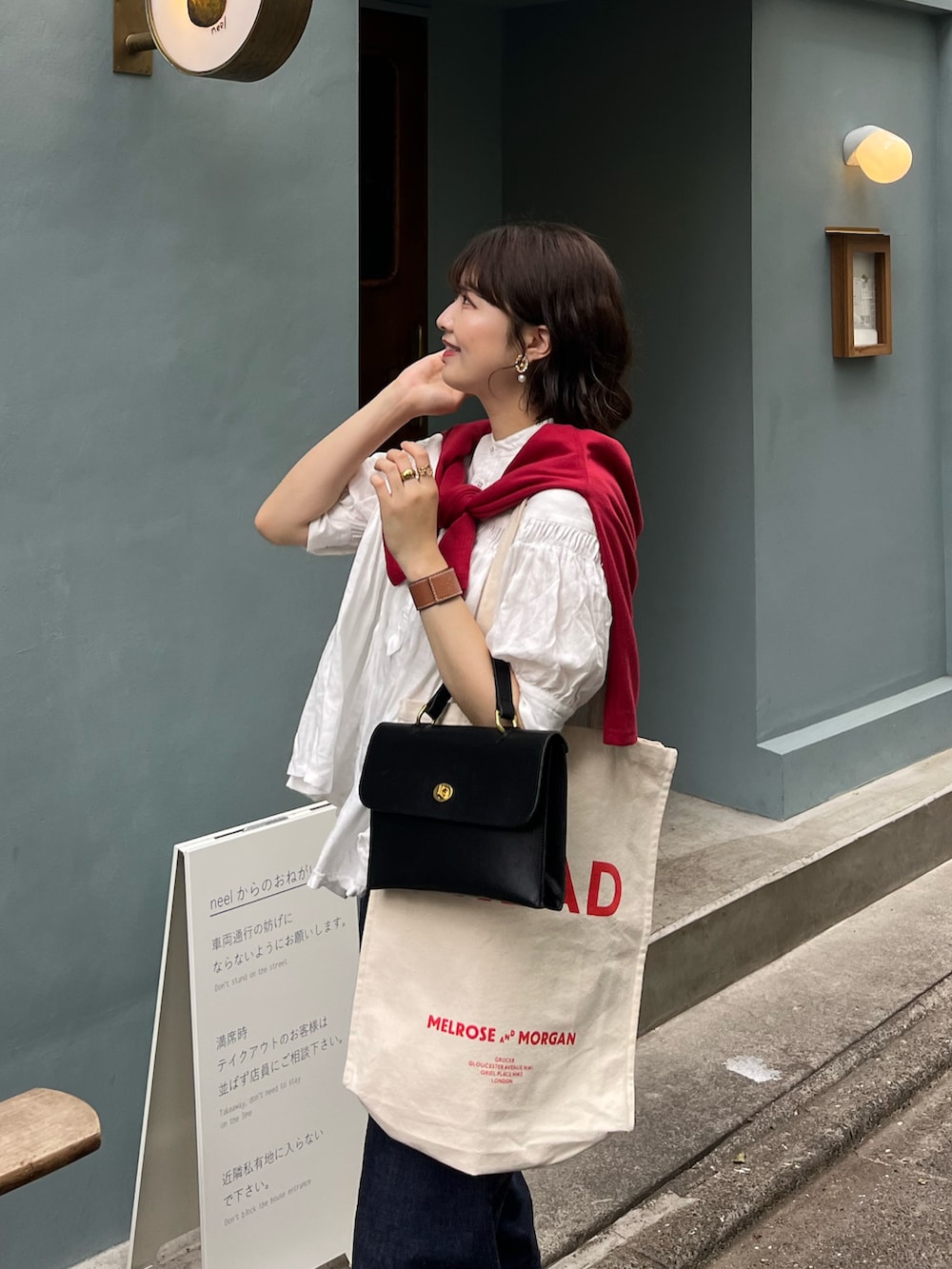 ブルー系のデニムパンツ、ブラック系のローファー、ブラック系のショルダーバッグを着用したレディースの夏コーディネートの2枚目の写真