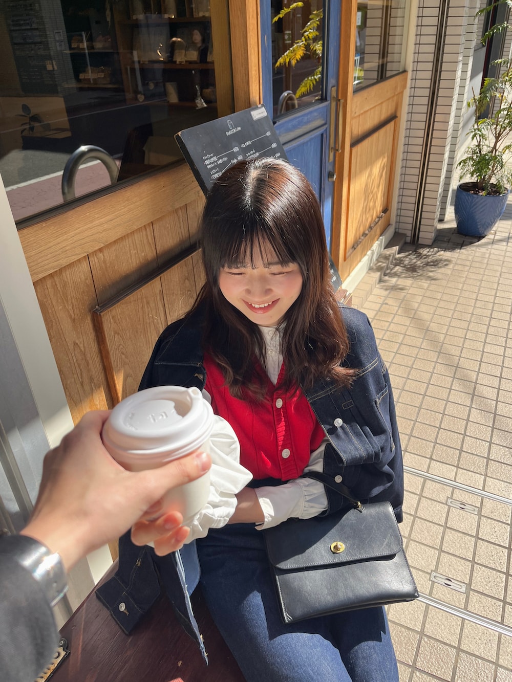 ブルー系のデニムパンツ、ブラック系のショルダーバッグ、ブルー系のデニムジャケットを着用したレディースの冬コーディネートの3枚目の写真