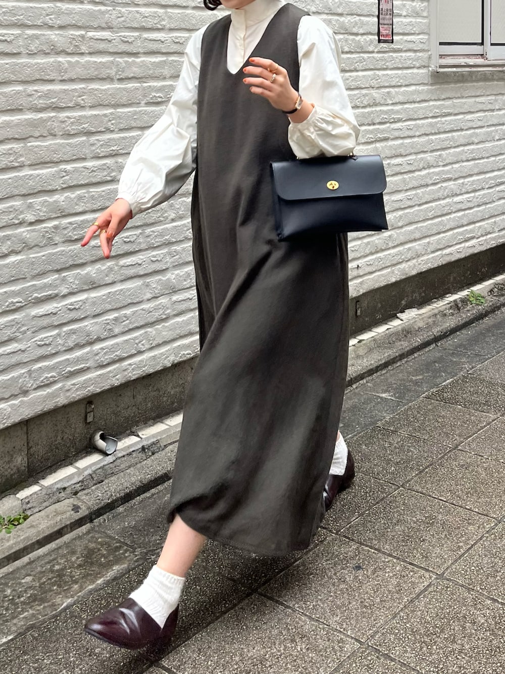 ブラウン系のドレスシューズ、グレー系のワンピース/ドレス、ホワイト系のシャツ/ブラウスを着用したレディースの冬コーディネートの2枚目の写真