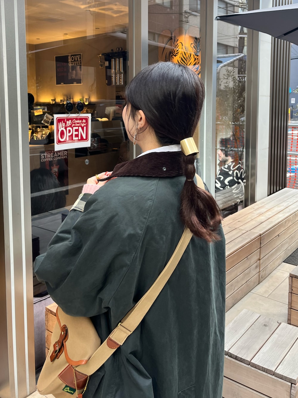 グリーン系のショルダーバッグ、グリーン系のスカート、ピンク系のニット/セーターを着用したレディースの冬コーディネートの2枚目の写真