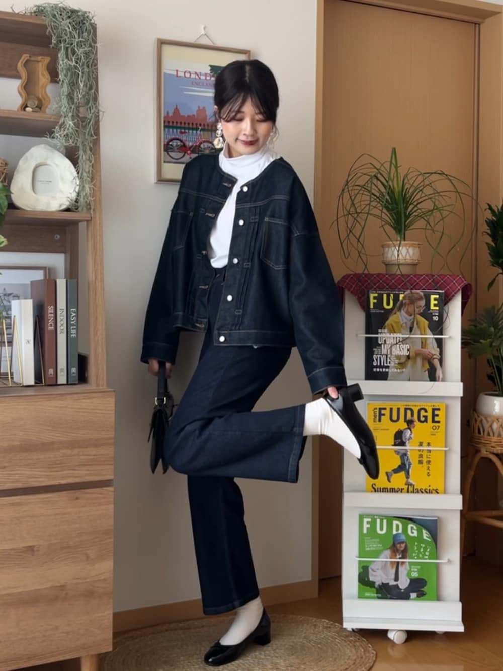 ブルー系のデニムパンツ、ブラック系のバレエシューズ、ブルー系のデニムジャケットを着用したレディースの秋コーディネートの2枚目の写真