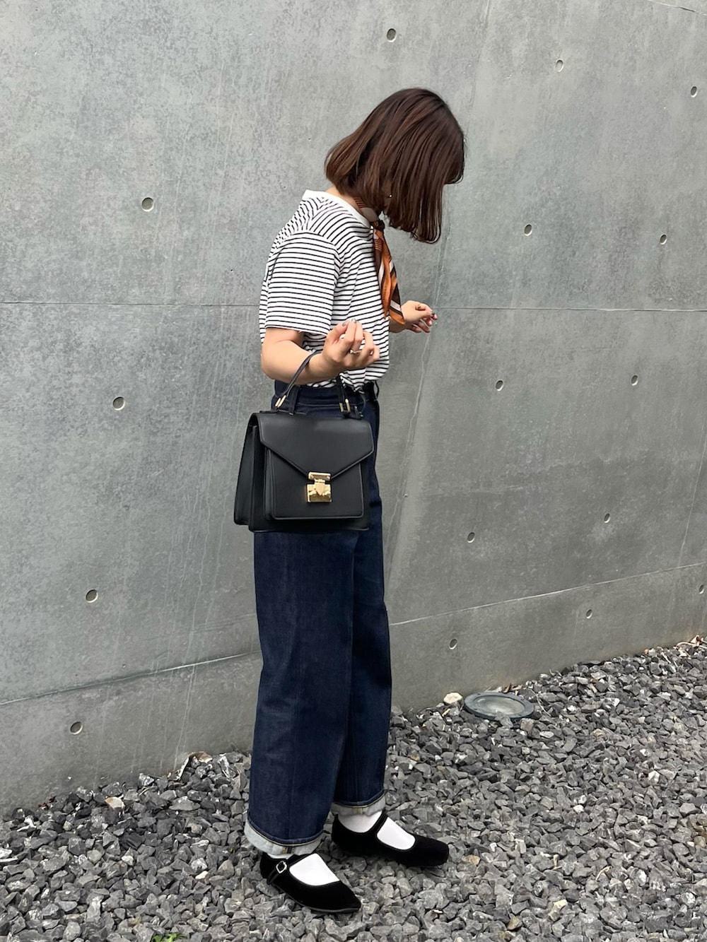 ブラック系のバレエシューズ、ブルー系のデニムパンツ、ブラック系のTシャツ/カットソーを着用したレディースの夏コーディネートの2枚目の写真