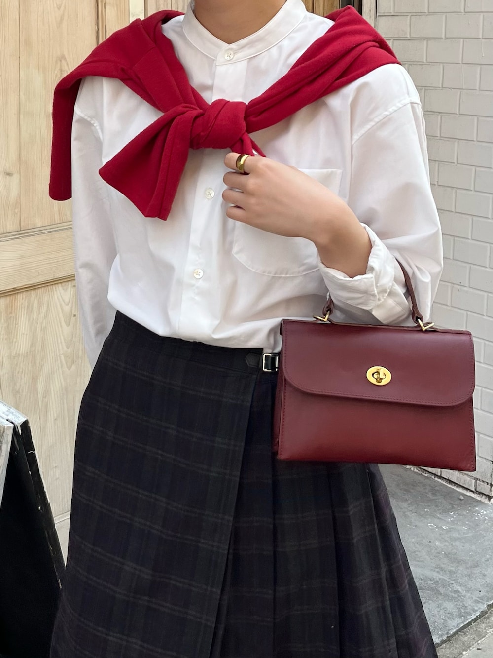 ブラック系のローファー、レッド系のショルダーバッグ、レッド系のカーディガン/ボレロを着用したレディースの春コーディネートの3枚目の写真