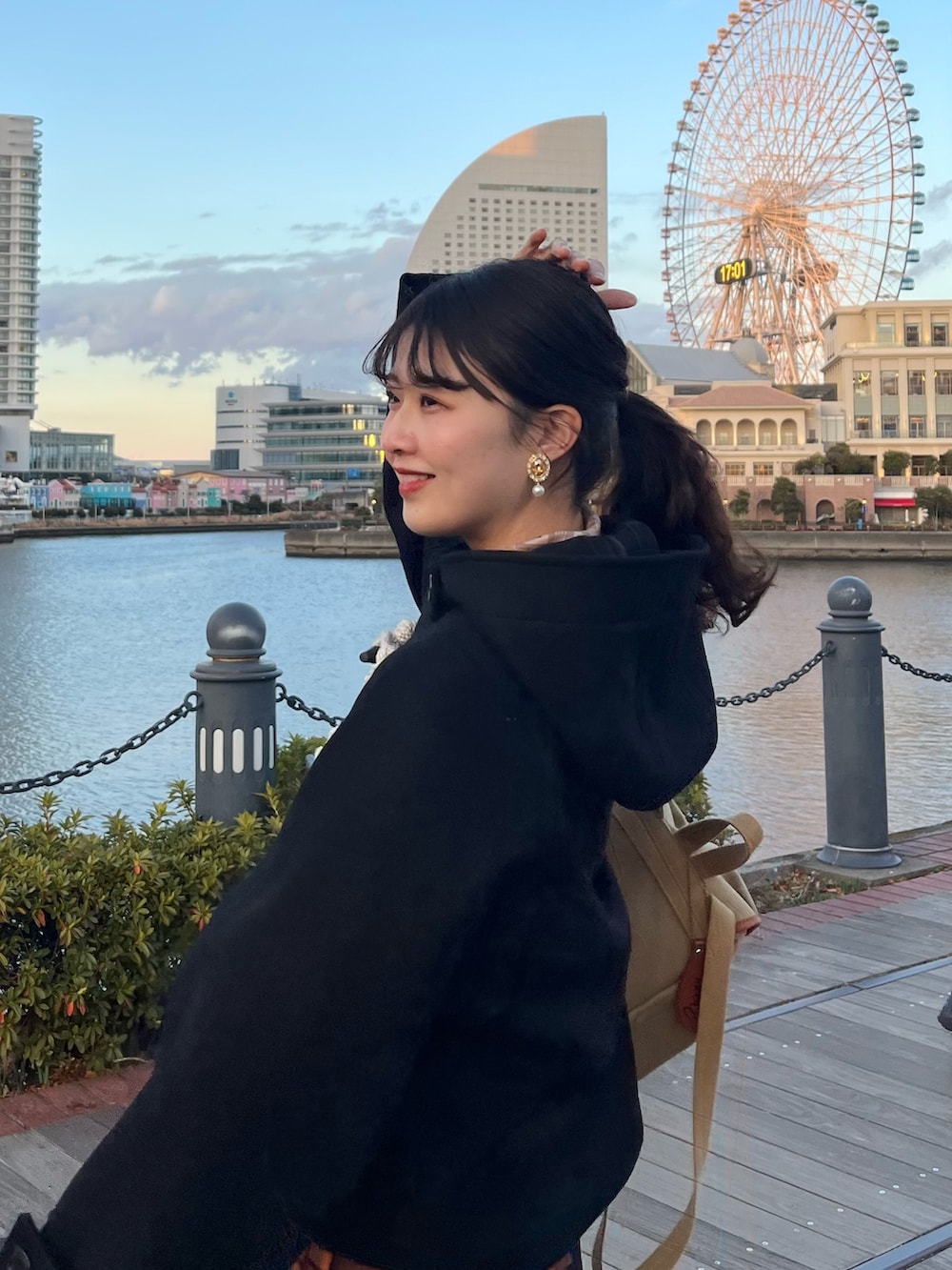 ベージュ系のバックパック/リュック、ブラック系のダッフルコート、オレンジ系のスカートを着用したレディースの冬コーディネートの2枚目の写真