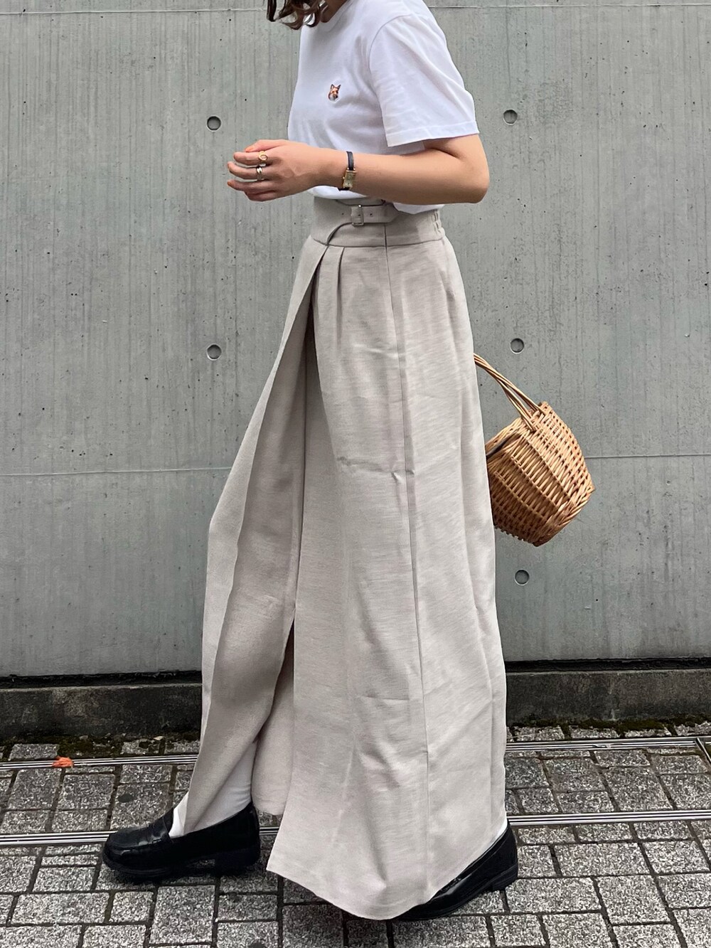 ホワイト系のTシャツ/カットソー、ベージュ系のかごバッグ、ベージュ系のスカートを着用したレディースの夏コーディネートの2枚目の写真