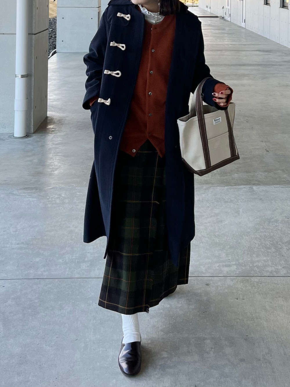 ブルー系のダッフルコート、ブラウン系のトートバッグ、グリーン系のスカートを着用したレディースの冬コーディネートの2枚目の写真