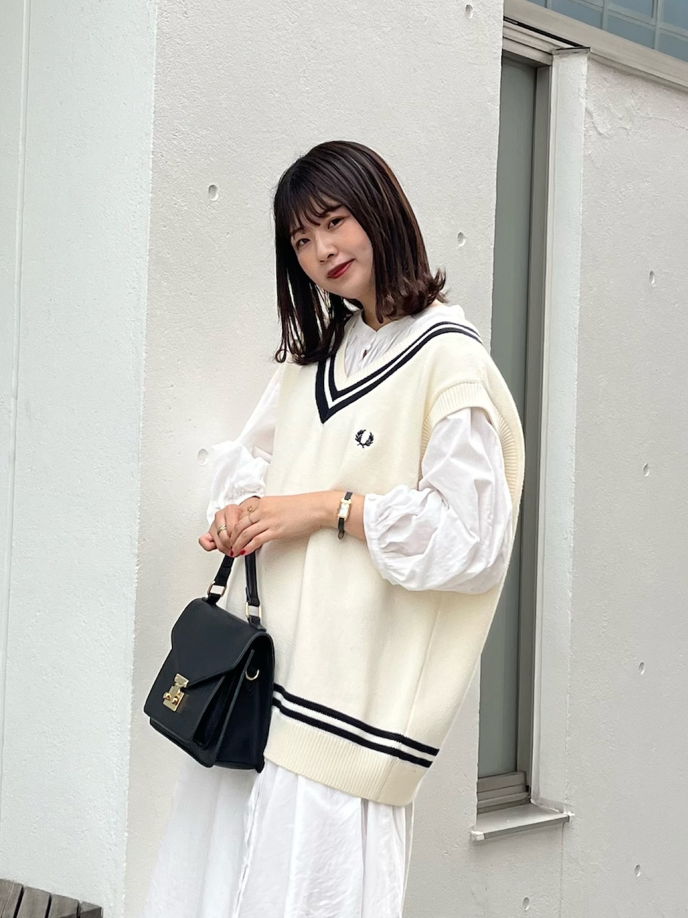 ホワイト系のベスト、ホワイト系のワンピース、ブラック系のローファーを着用したレディースの夏コーディネートの2枚目の写真