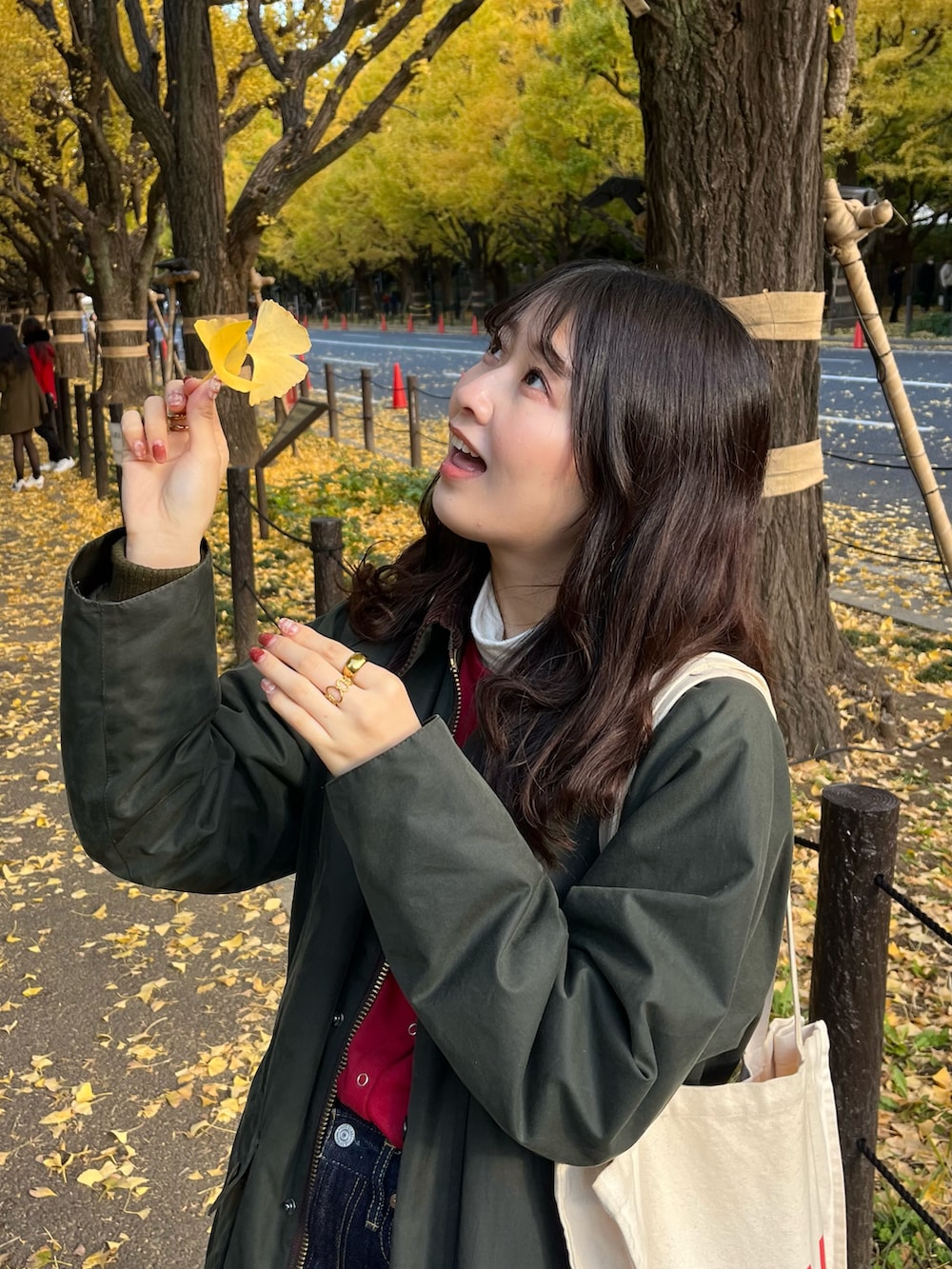 ブルー系のデニムスカート、ブラウン系のブーツ、レッド系のカーディガン/ボレロを着用したレディースの秋コーディネートの2枚目の写真