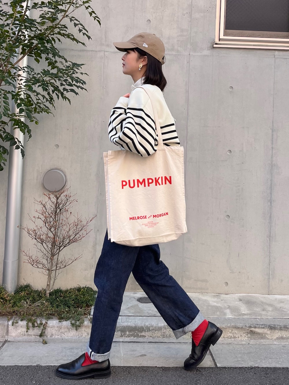 ブルー系のデニムパンツ、ブラック系のドレスシューズ、ホワイト系のニット/セーターを着用したレディースの冬コーディネートの2枚目の写真