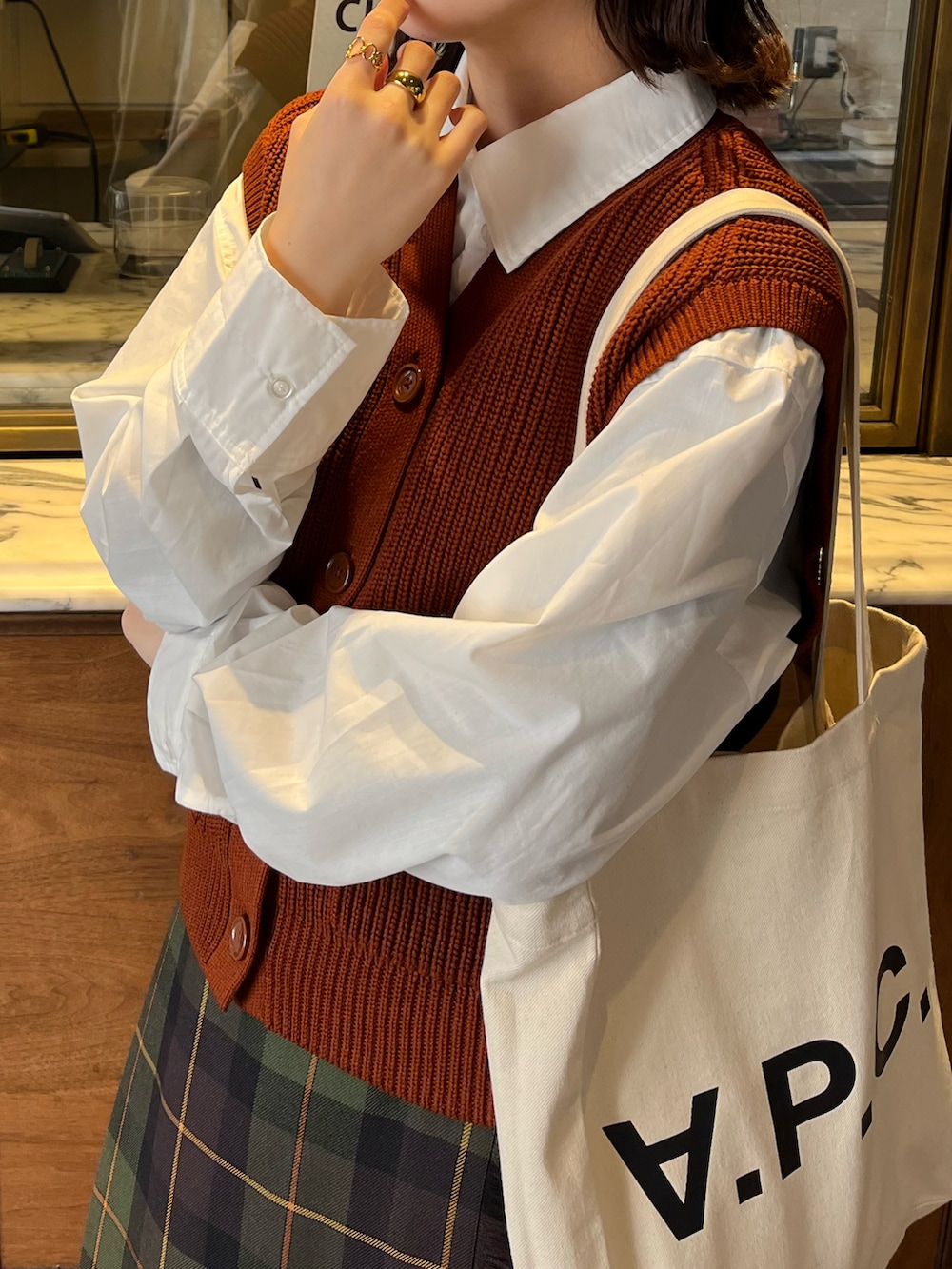 ホワイト系のトートバッグ、ホワイト系のシャツ/ブラウス、グリーン系のスカートを着用したレディースの冬コーディネートの2枚目の写真