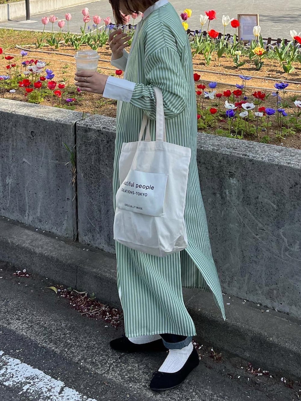 ブラック系のバレエシューズ、ホワイト系のトートバッグ、グリーン系のワンピースを着用したレディースの春コーディネートの3枚目の写真