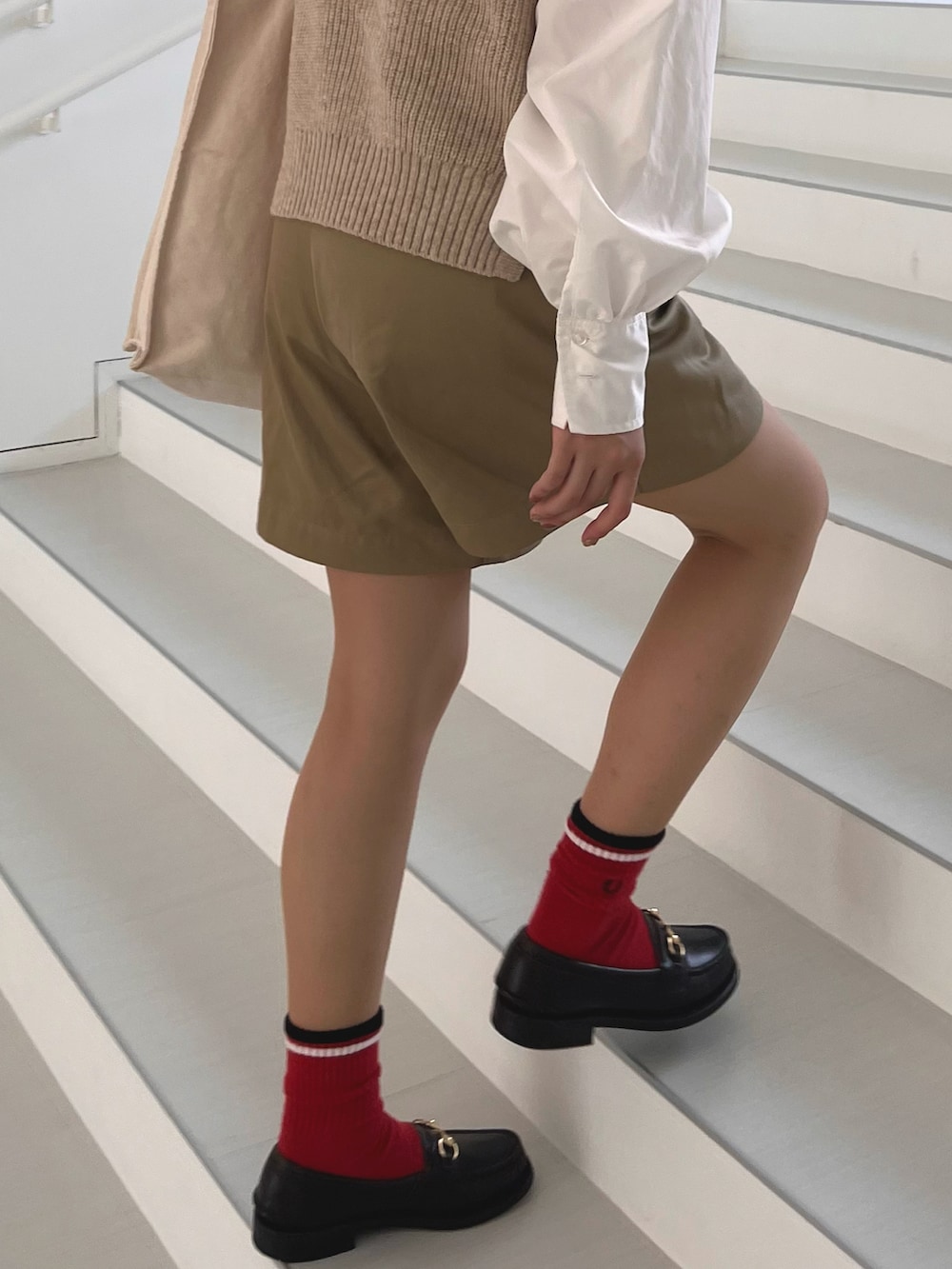 ブラック系のローファー、ベージュ系のベスト、ベージュ系のその他パンツを着用したレディースの夏コーディネートの3枚目の写真