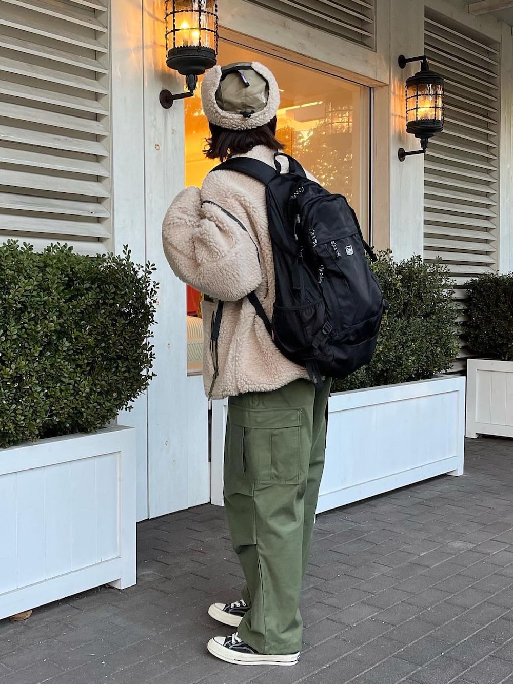 ブラック系のスニーカー、ベージュ系のブルゾン、グリーン系のパンツを着用したレディースの冬コーディネートの2枚目の写真