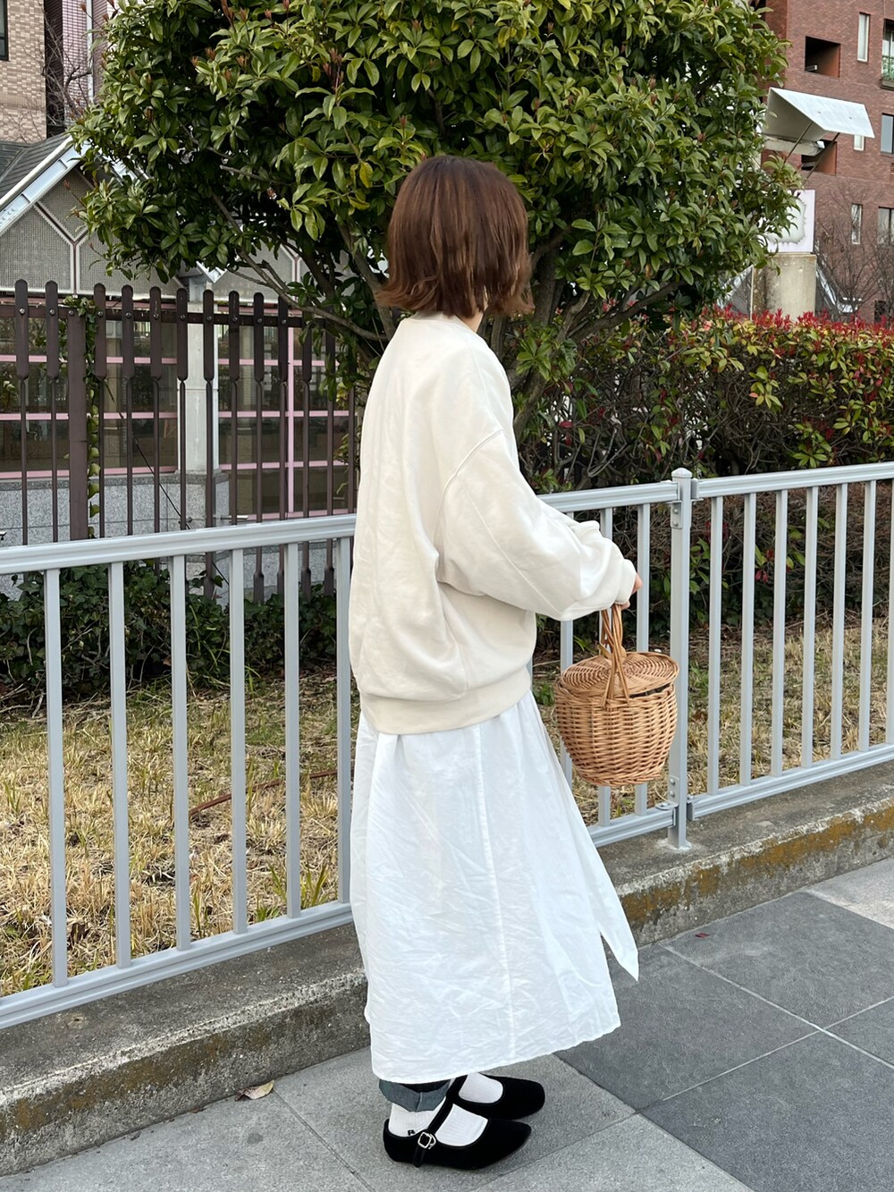 ホワイト系のスウェット、ホワイト系のシャツワンピース、ベージュ系のかごバッグを着用したレディースの春コーディネートの2枚目の写真