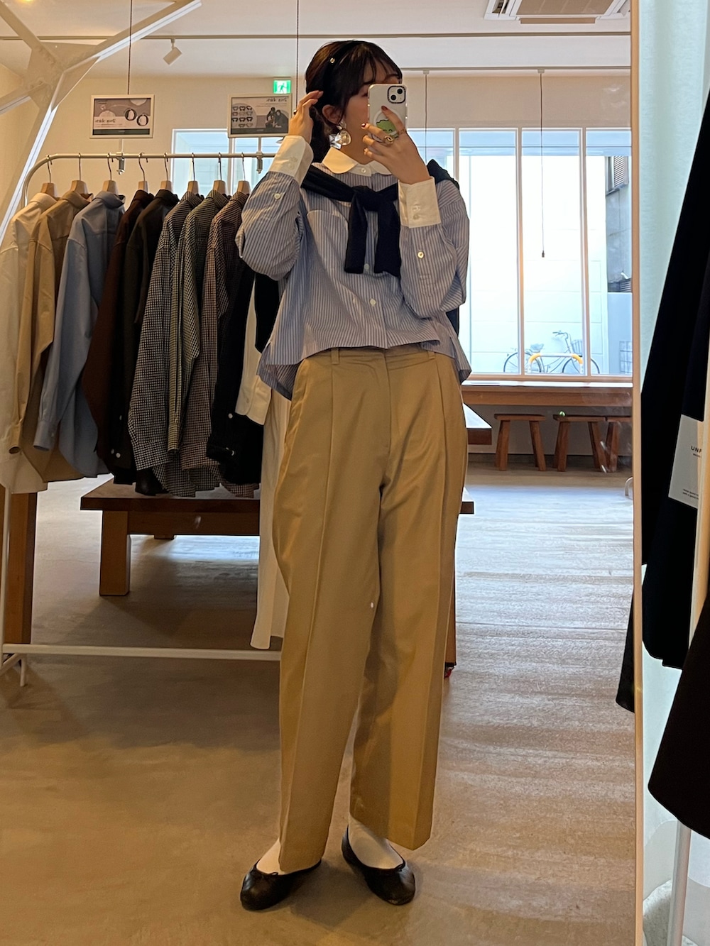 ベージュ系のチノパンツ、ブラック系のバレエシューズ、ブルー系のシャツ/ブラウスを着用したレディースの冬コーディネートの2枚目の写真