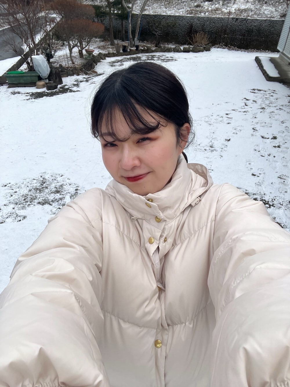 ホワイト系のダウンジャケット/コート、ベージュ系のスカート、ブラウン系のブーツを着用したレディースの冬コーディネートの4枚目の写真