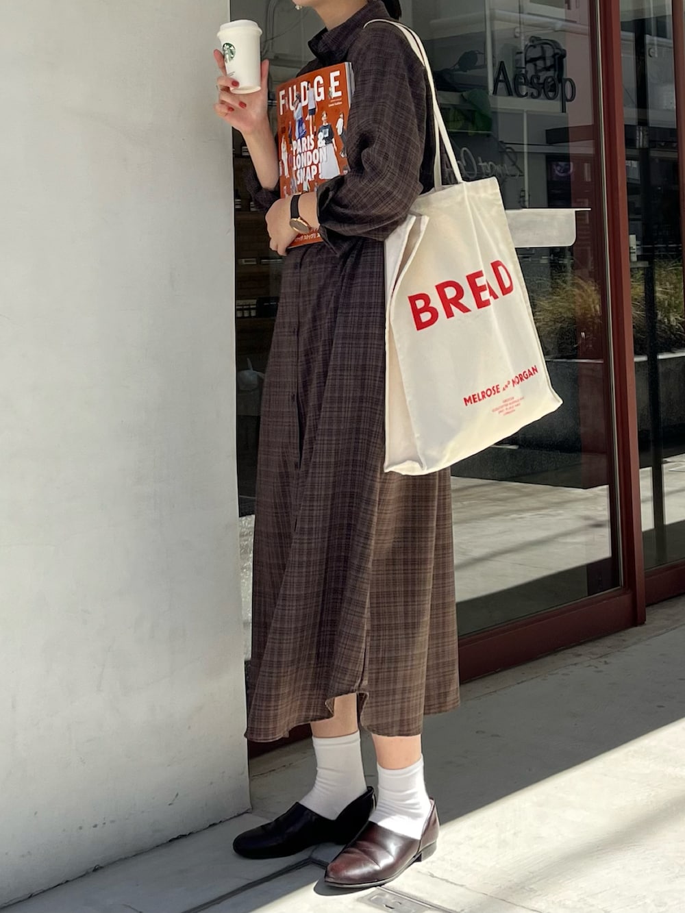 ブラウン系のドレスシューズ、ブラック系のシャツワンピース、その他のトートバッグを着用したレディースの夏コーディネートの3枚目の写真