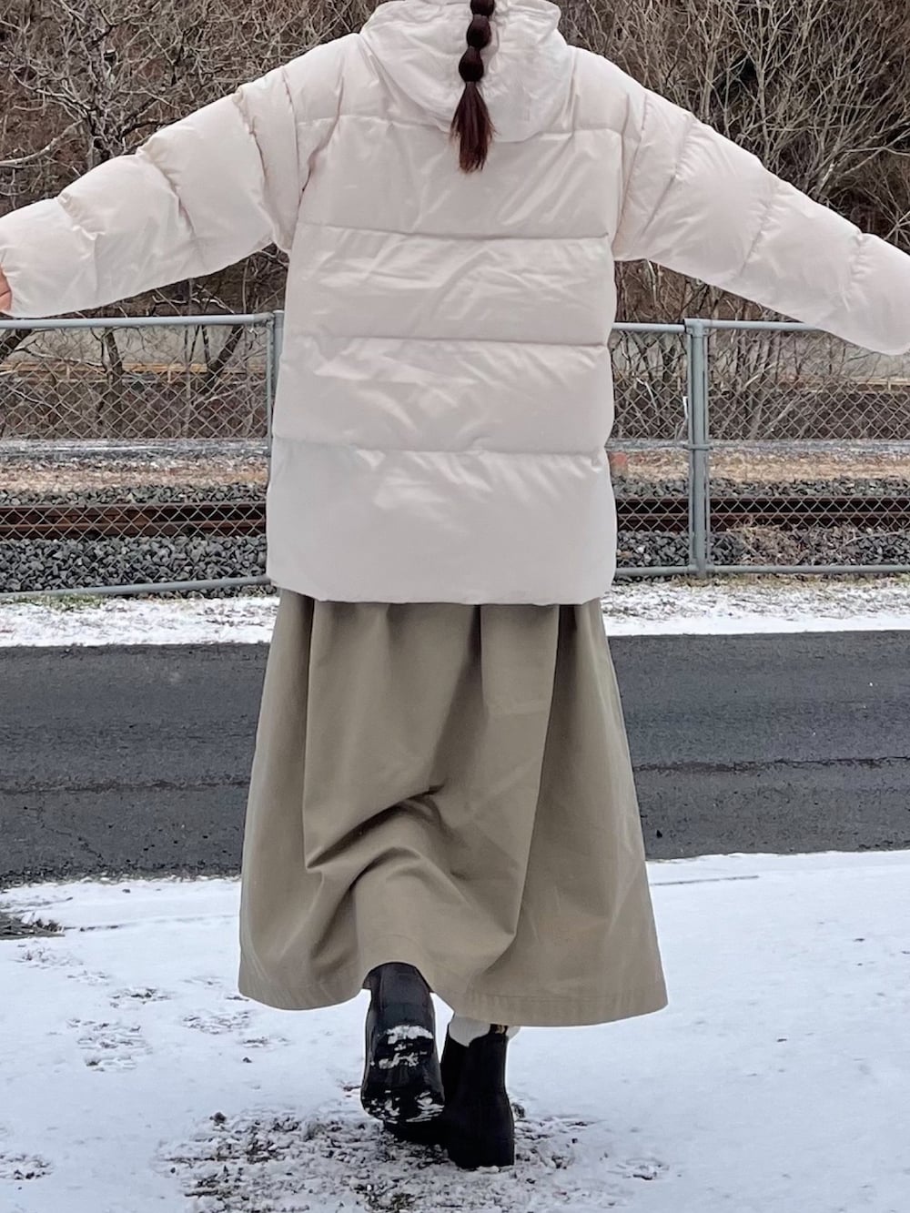 ホワイト系のダウンジャケット/コート、ベージュ系のスカート、ブラウン系のブーツを着用したレディースの冬コーディネートの3枚目の写真