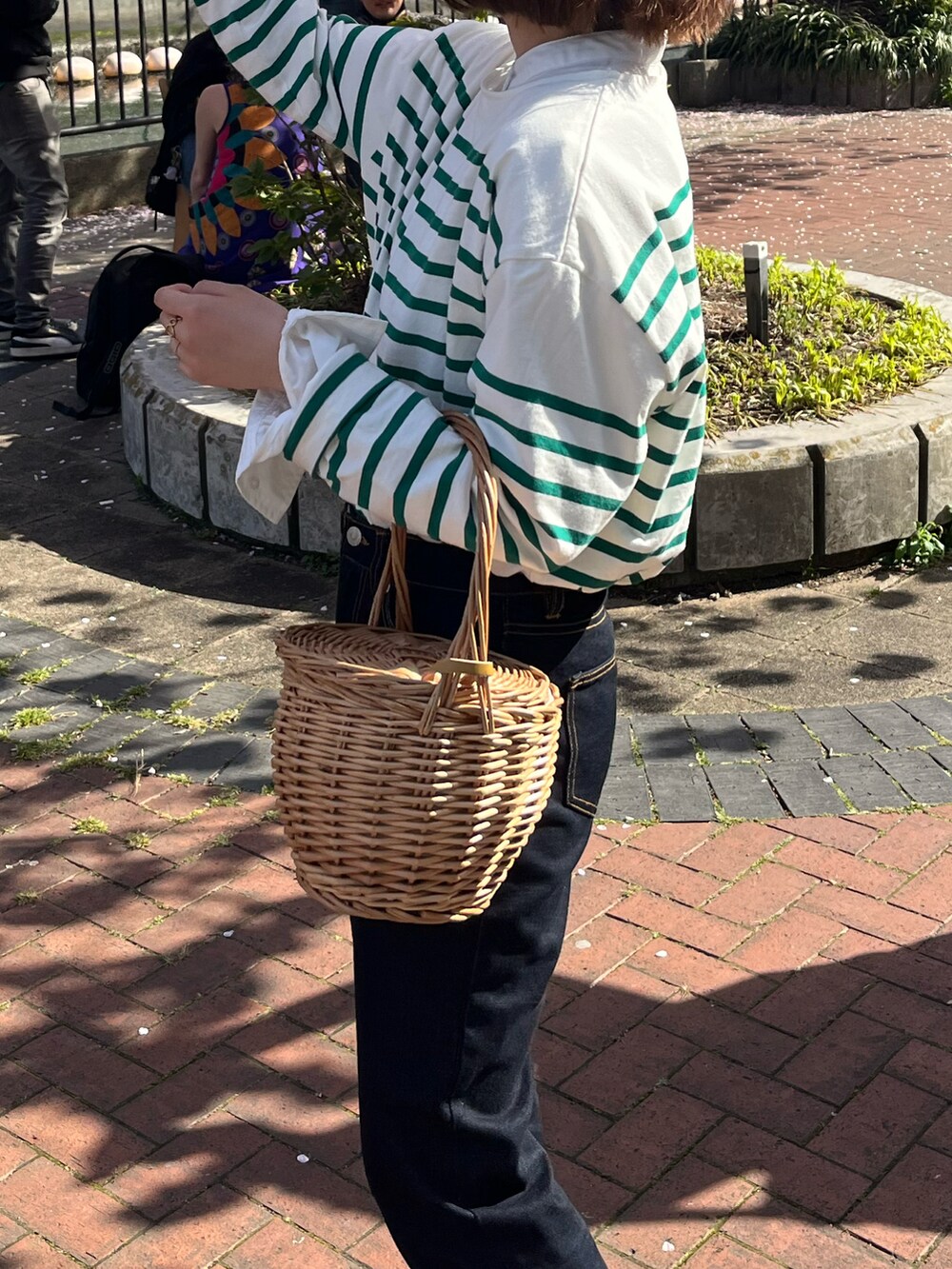 グリーン系のTシャツ/カットソー、ブラック系のバレエシューズ、ブルー系のデニムパンツを着用したレディースの春コーディネートの4枚目の写真