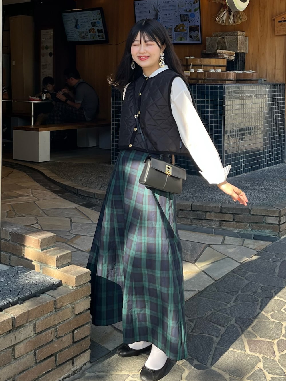 ブラック系のバレエシューズ、ブラック系のショルダーバッグ、ブラック系のその他アウターを着用したレディースの秋コーディネートの2枚目の写真