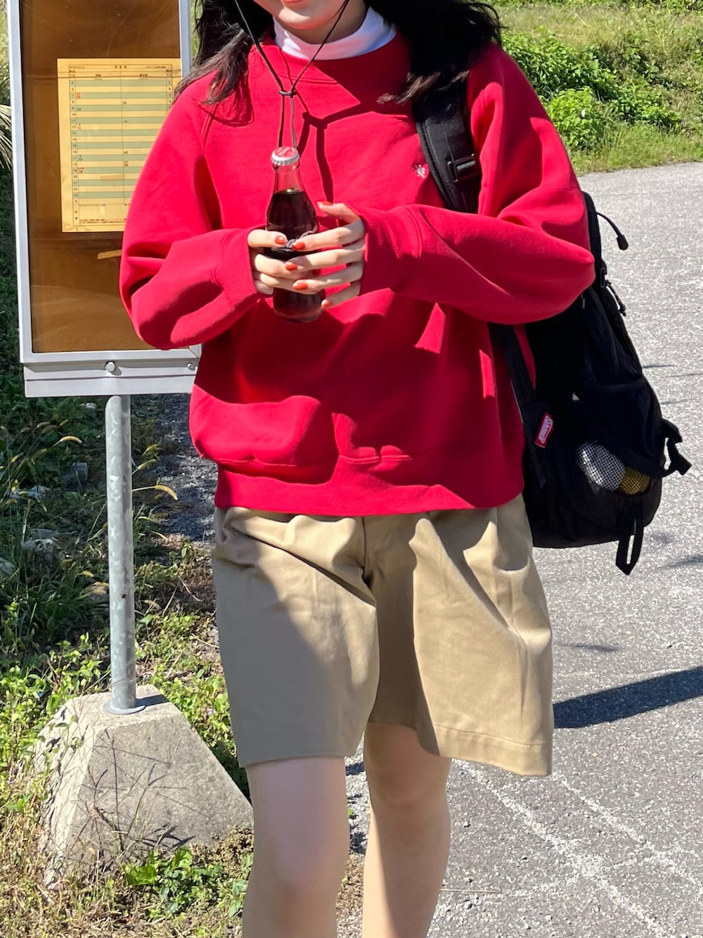 レッド系のスニーカー、ベージュ系のその他パンツ、レッド系のスウェットを着用したレディースの秋コーディネートの2枚目の写真