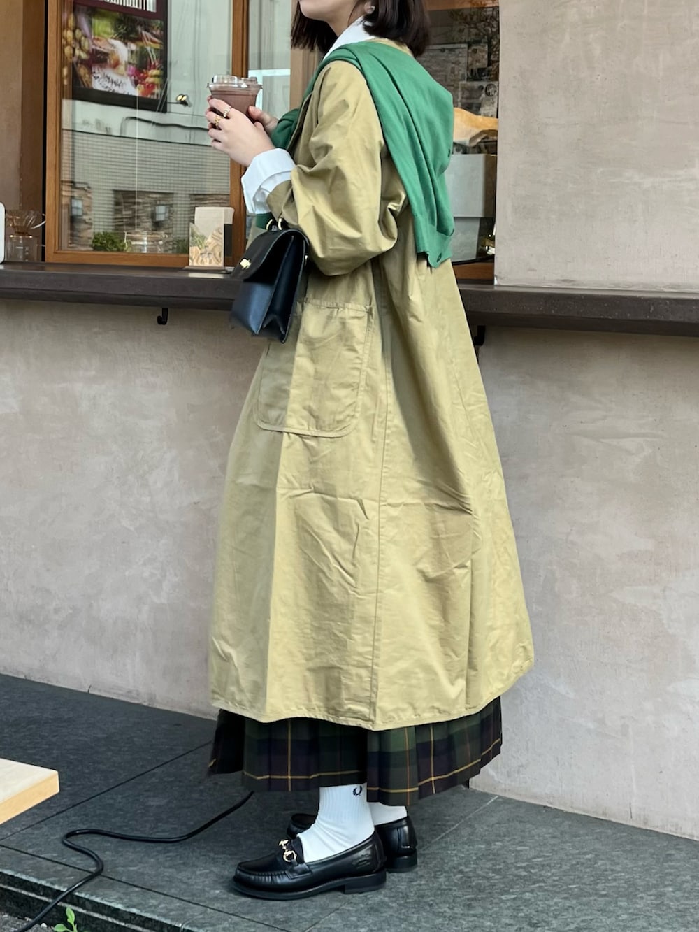 ブラック系のショルダーバッグ、ホワイト系のシャツ/ブラウス、ベージュ系のノーカラーコートを着用したレディースの冬コーディネートの2枚目の写真