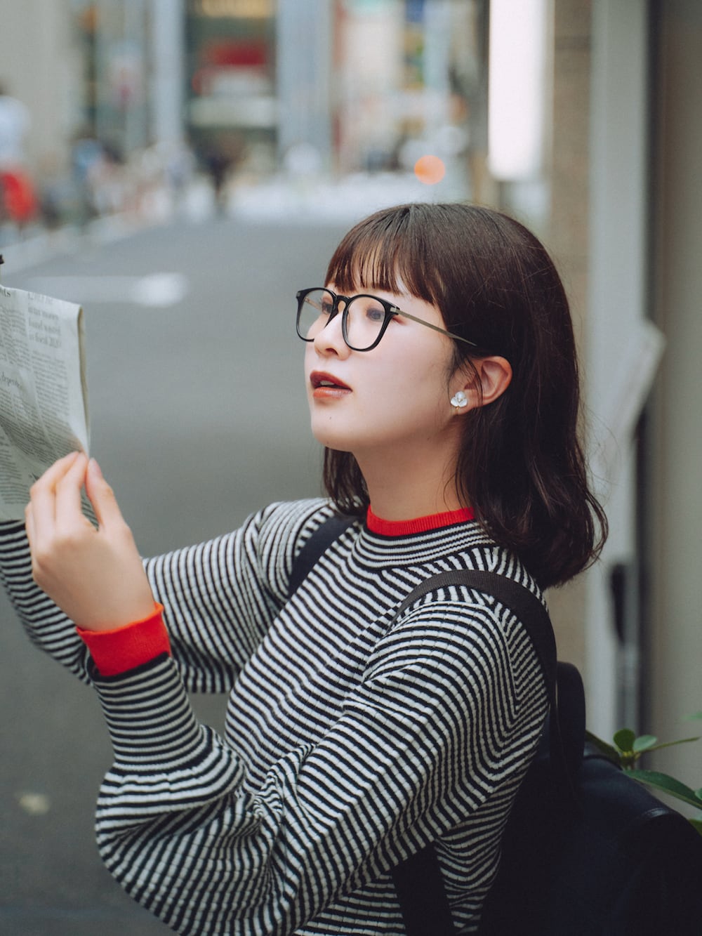 ブルー系のデニムパンツ、ブラック系のニット/セーター、ブラック系のバレエシューズを着用したレディースの秋コーディネートの2枚目の写真