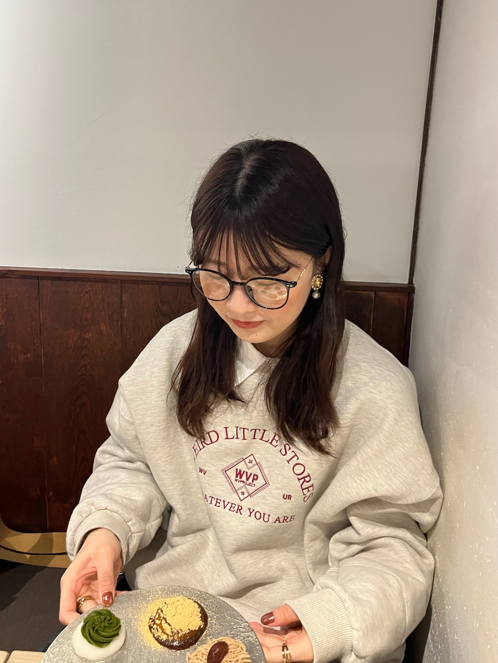 グリーン系のスカート、ブラウン系のローファー、グレー系のスウェットを着用したレディースの春コーディネートの2枚目の写真