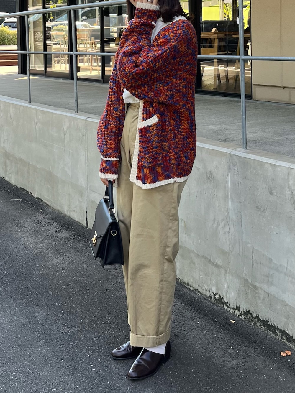 ホワイト系のシャツ/ブラウス、オレンジ系のカーディガン/ボレロ、ベージュ系のチノパンツを着用したレディースの秋コーディネートの2枚目の写真