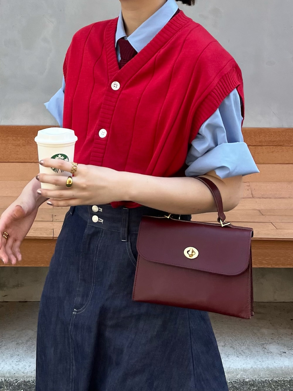 ブラック系のバレエシューズ、レッド系のショルダーバッグ、ブルー系のデニムスカートを着用したレディースの春コーディネートの2枚目の写真