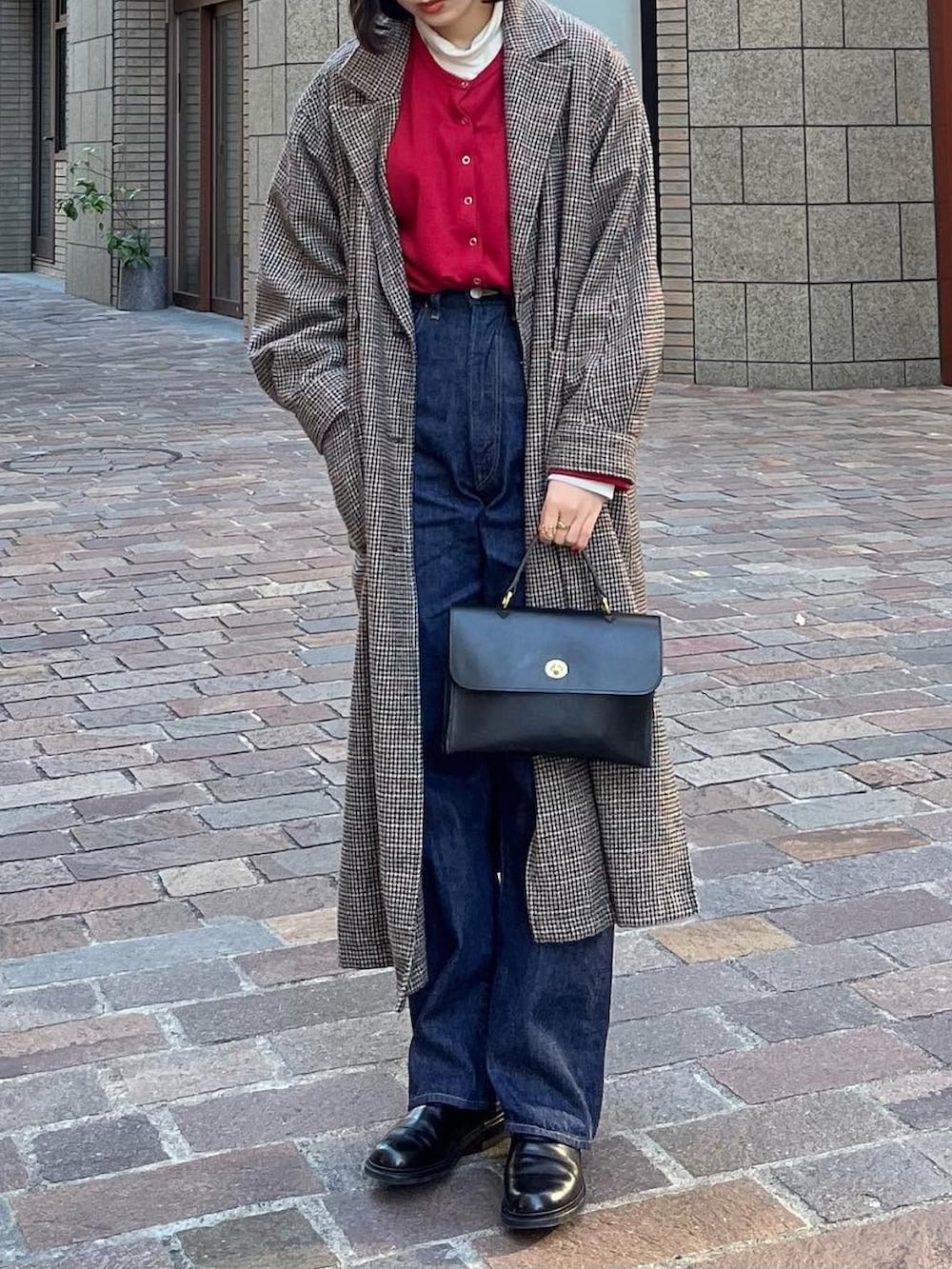 ブルー系のデニムパンツ、レッド系のカーディガン/ボレロ、グレー系のその他アウターを着用したレディースの冬コーディネートの2枚目の写真