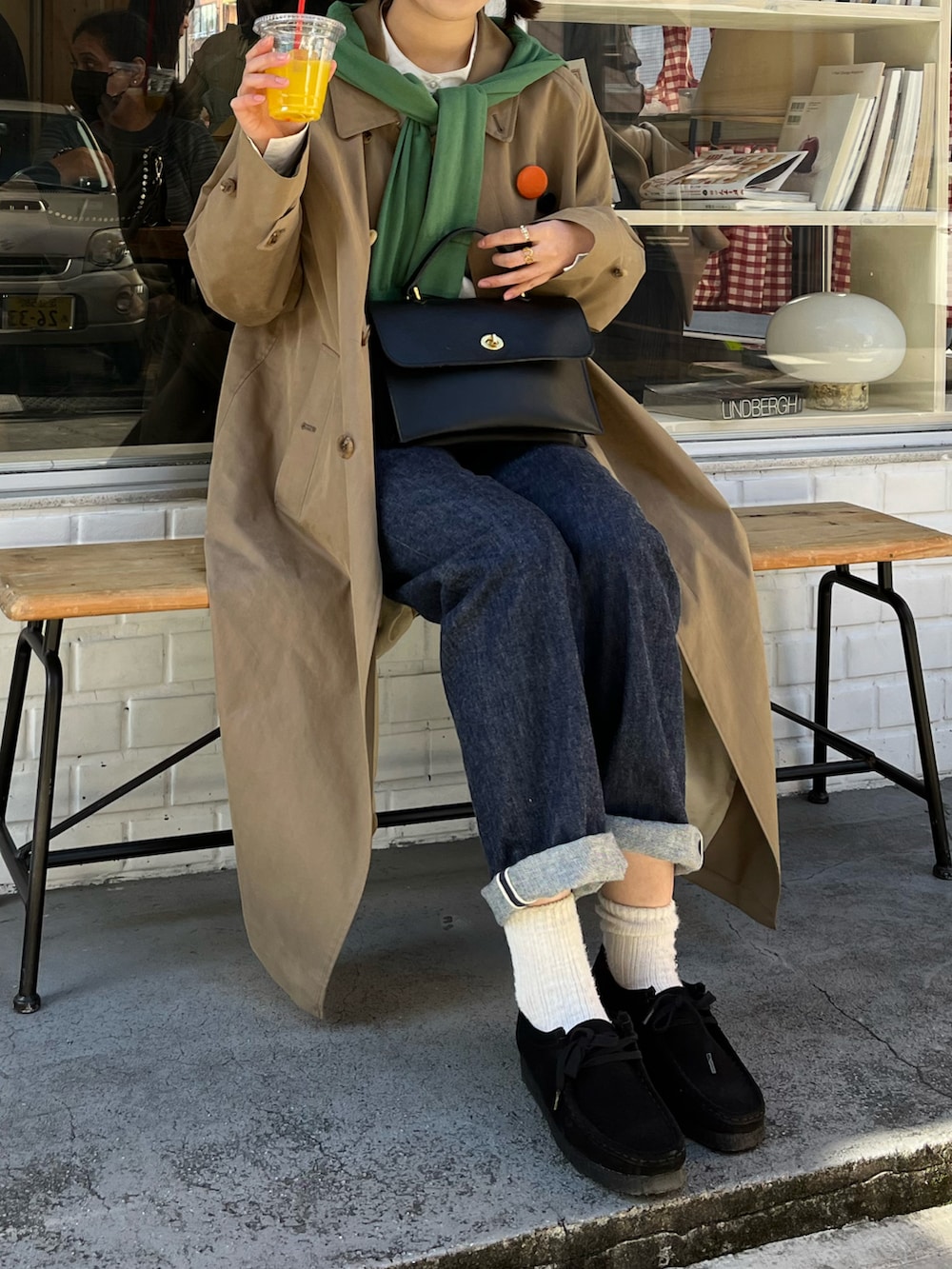 ブラック系のモカシン/デッキシューズ、ブルー系のデニムパンツ、ブラック系のショルダーバッグを着用したレディースの冬コーディネートの2枚目の写真