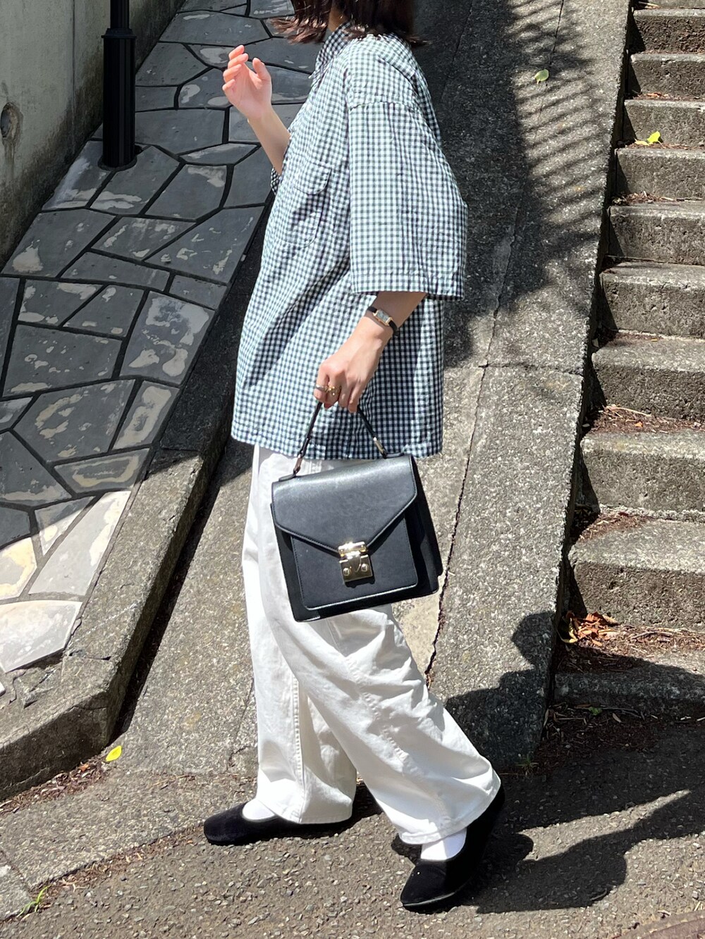 ホワイト系のデニムパンツ、ブラック系のトートバッグ、グリーン系のシャツ/ブラウスを着用したレディースの夏コーディネートの2枚目の写真