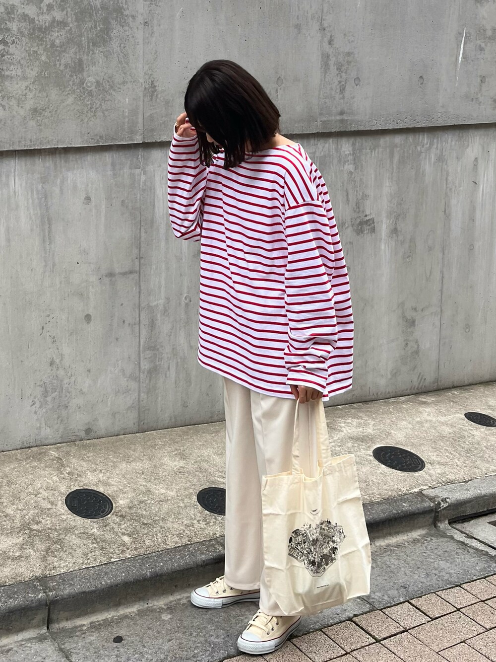 レッド系のトップス、ホワイト系のバッグ、ホワイト系のその他パンツを着用したレディースの春コーディネートの2枚目の写真