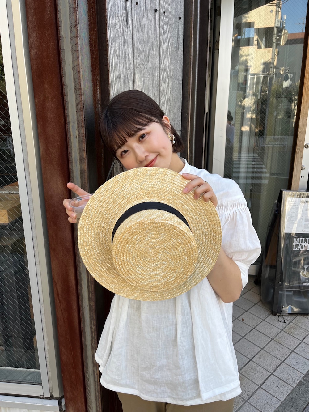 ベージュ系のチノパンツ、ホワイト系のシャツ/ブラウス、ブラウン系のドレスシューズを着用したレディースの夏コーディネートの2枚目の写真