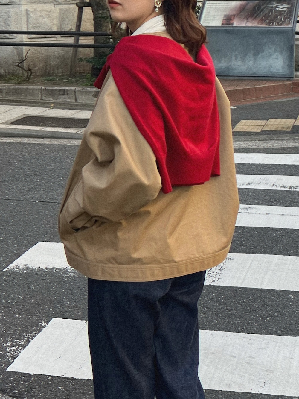 ブルー系のデニムパンツ、ブラウン系のドレスシューズ、グリーン系のトートバッグを着用したレディースの冬コーディネートの2枚目の写真