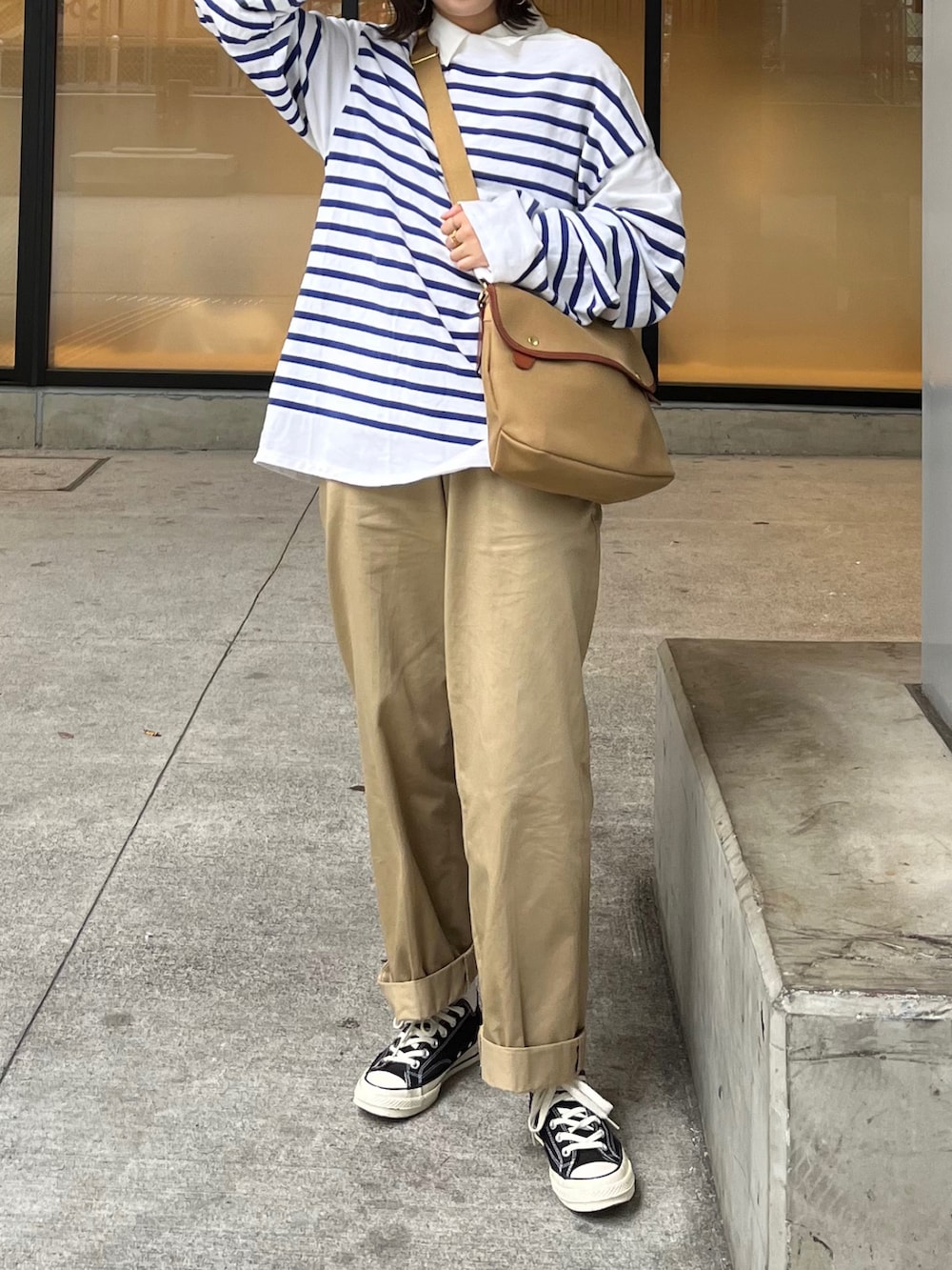 ベージュ系のショルダーバッグ、ブルー系のTシャツ/カットソー、ベージュ系のチノパンツを着用したレディースの春コーディネートの4枚目の写真