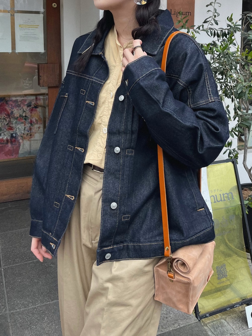 ブラウン系のローファー、イエロー系のシャツ/ブラウス、ブルー系のデニムジャケットを着用したレディースの春コーディネートの2枚目の写真