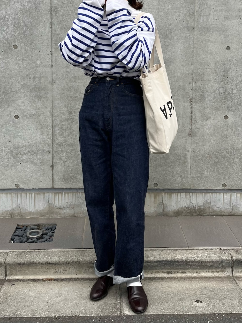 ホワイト系のトートバッグ、ブルー系のデニムパンツ、ブルー系のTシャツ/カットソーを着用したレディースの春コーディネートの2枚目の写真