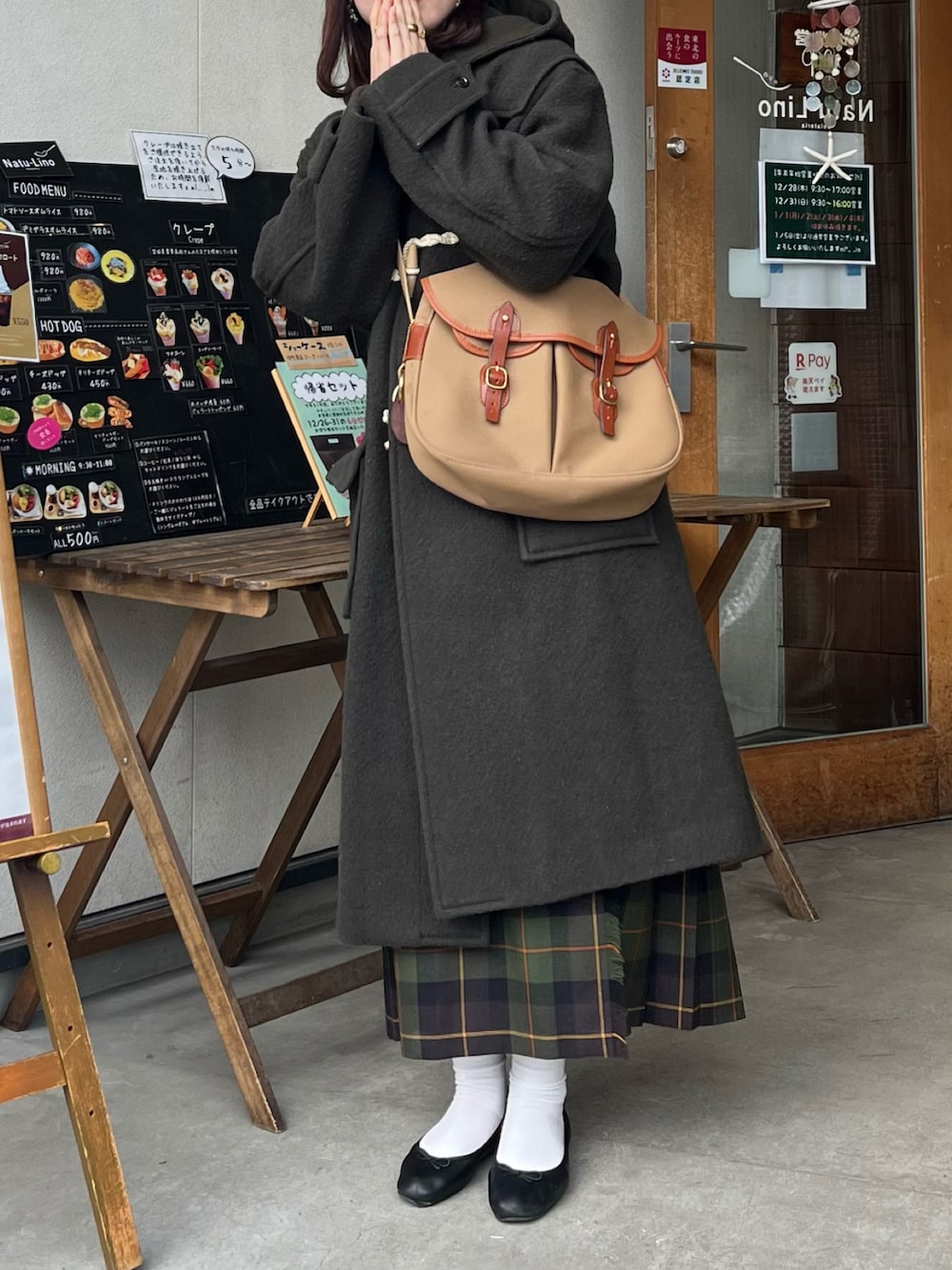 グリーン系のショルダーバッグ、グリーン系のダッフルコート、グリーン系のスカートを着用したレディースの冬コーディネートの2枚目の写真