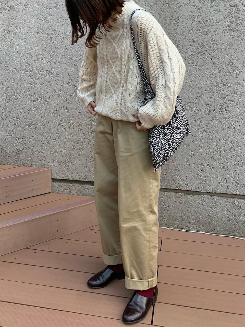 ベージュ系のチノパンツ、ベージュ系のニット/セーター、ブラウン系のドレスシューズを着用したレディースの秋コーディネートの2枚目の写真