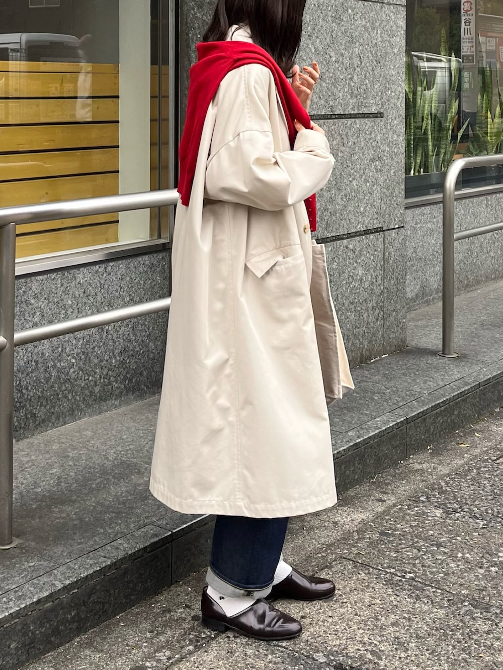 レッド系のニット/セーター、ブルー系のデニムパンツ、ホワイト系のジャケット/アウターを着用したレディースの秋コーディネートの2枚目の写真