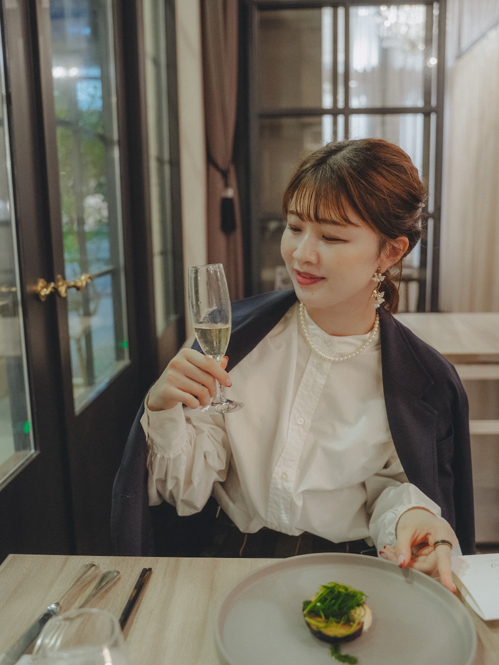 ブルー系のテーラードジャケット、グリーン系のスカート、ブラック系のショルダーバッグを着用したレディースの秋コーディネートの2枚目の写真