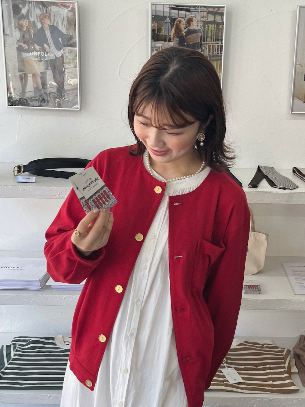 ブラウン系のローファー、レッド系のカーディガン/ボレロ、ホワイト系のワンピースを着用したレディースの夏コーディネートの2枚目の写真